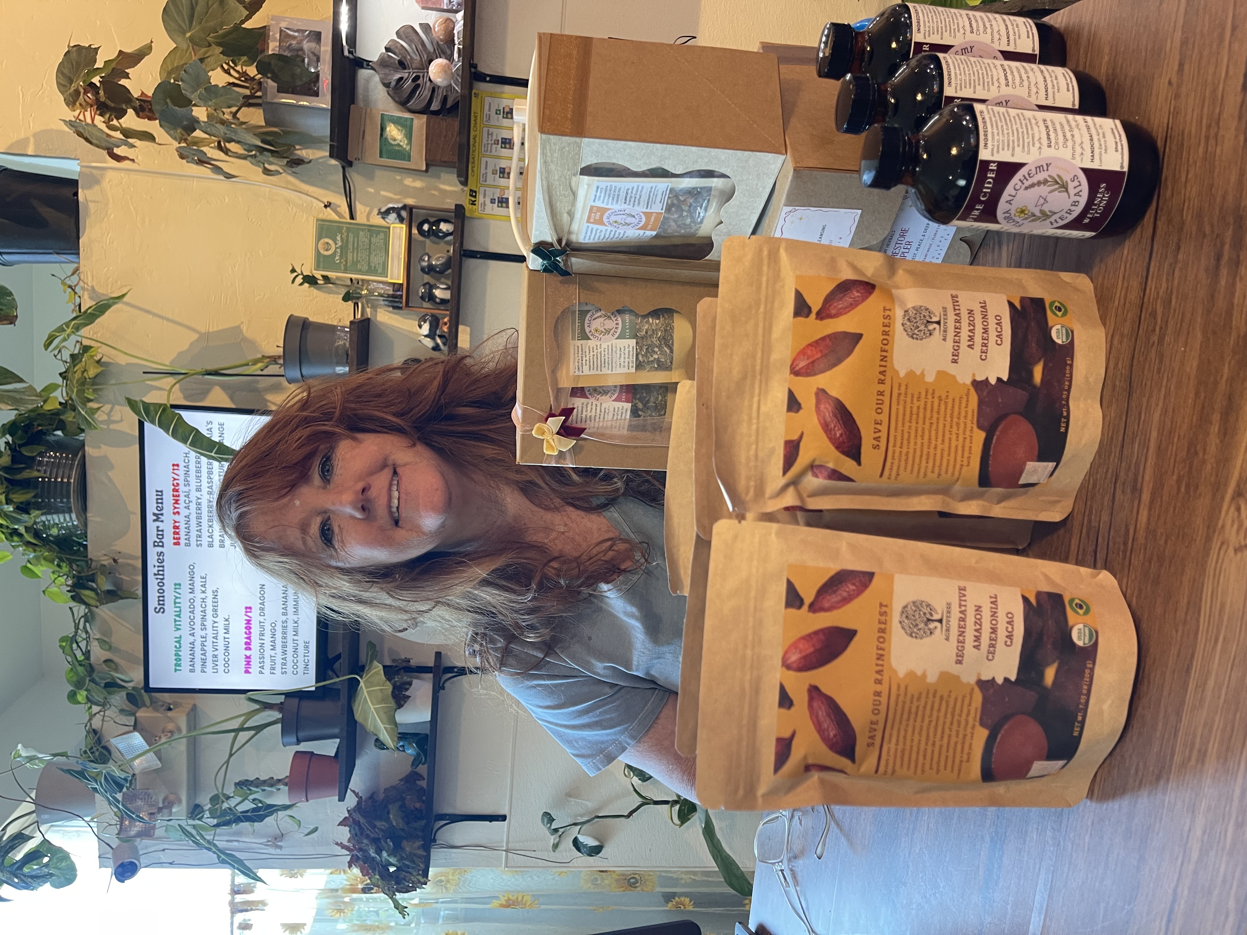 Summer posing with Agroverse ceremonial cacao bags behind her counter