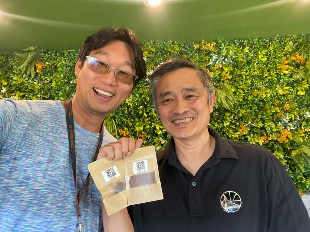 Dennis Lim and Gary Teh holding bags of cacao